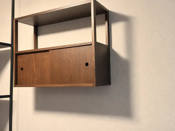 Wall-mounted wood storage cabinet installed on a finished wall