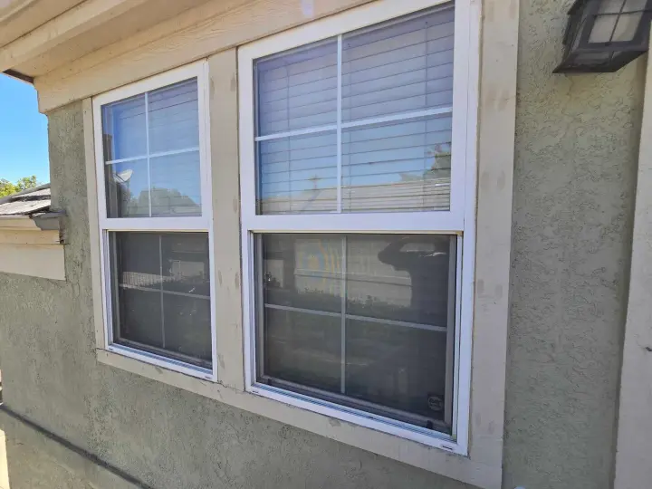 Windows with new exterior trim on a stucco house