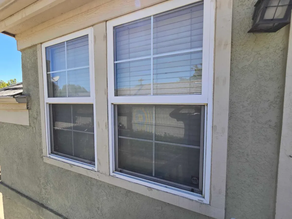 Windows with new exterior trim on a stucco house