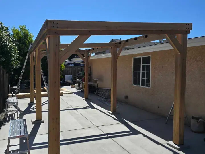 New wood pergola built over a backyard concrete patio