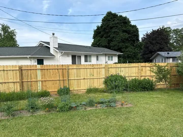 New wood privacy fence along a backyard lawn