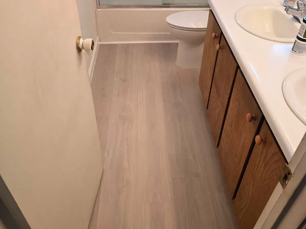 Bathroom with new plank flooring and baseboard trim