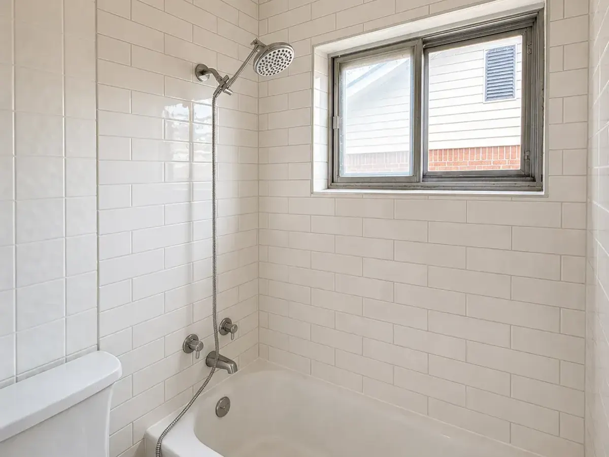 Bathroom with new white subway tile around the tub and shower
