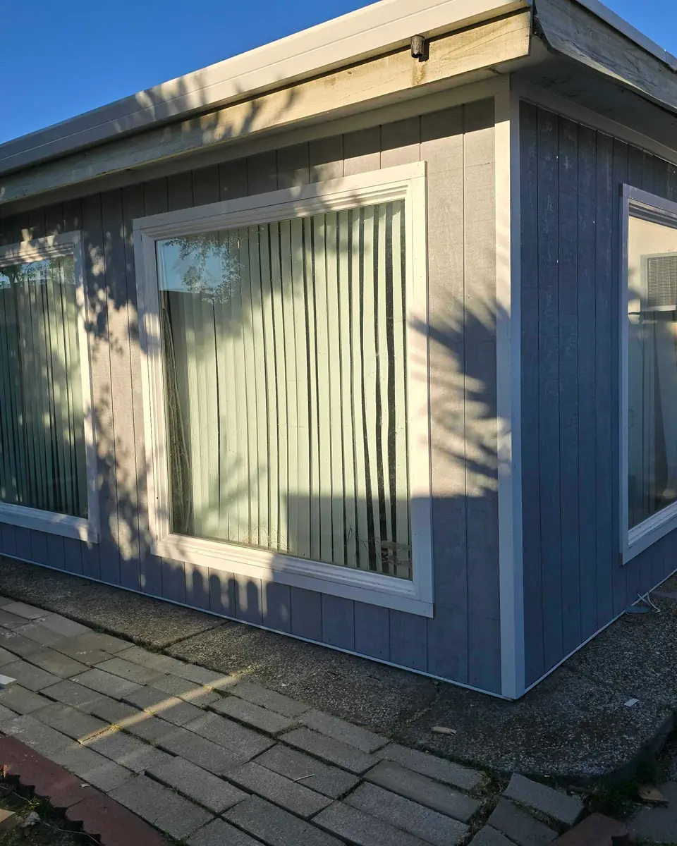 Completed exterior wall with new panel siding and white trim