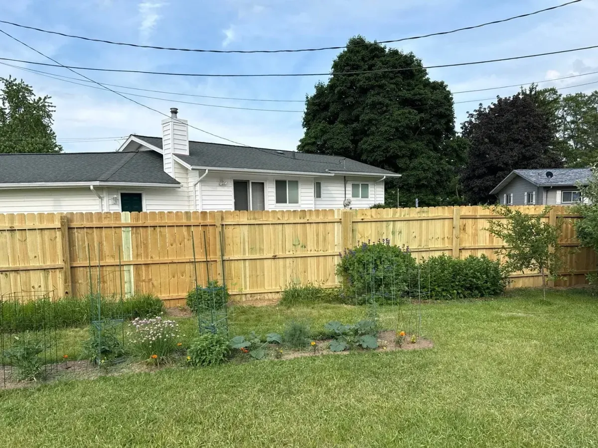 New wood privacy fence along a backyard lawn; shared Steady Craftsman project example