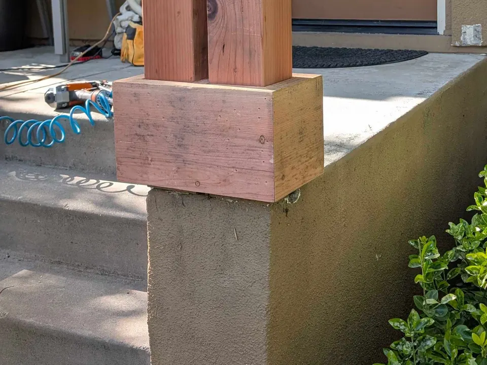 Unfinished replacement porch post beside the steps during work