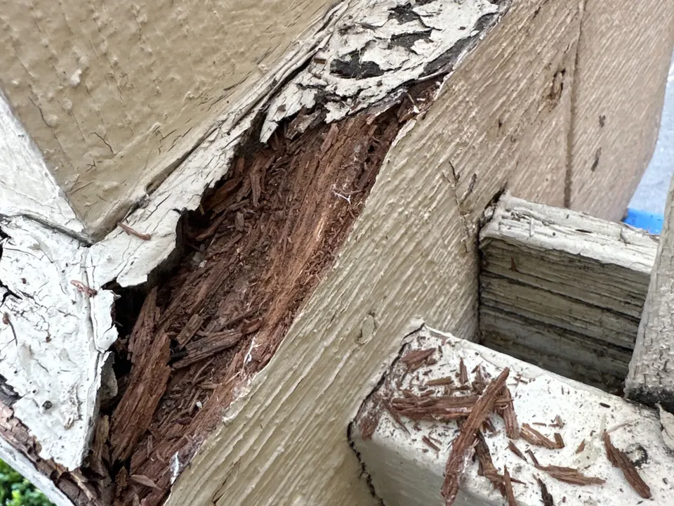 Deteriorated painted wood at a porch railing connection